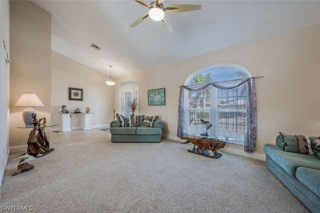 carpeted living room with ceiling fan and high vaulted ceiling