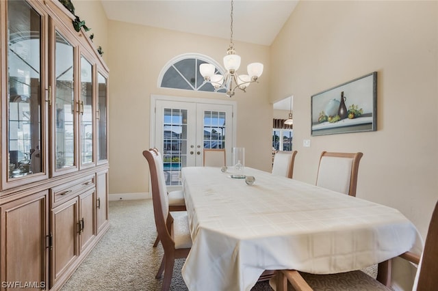 dining area with light carpet, french doors, an inviting chandelier, and high vaulted ceiling