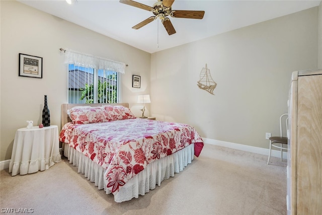 bedroom featuring white refrigerator, ceiling fan, and light colored carpet