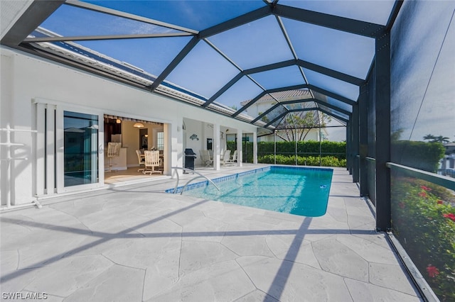 view of pool with glass enclosure and a patio