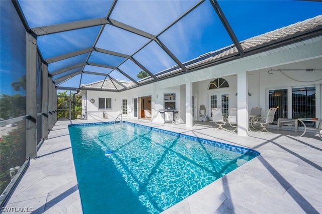 view of pool with french doors, ceiling fan, a lanai, a patio, and a grill