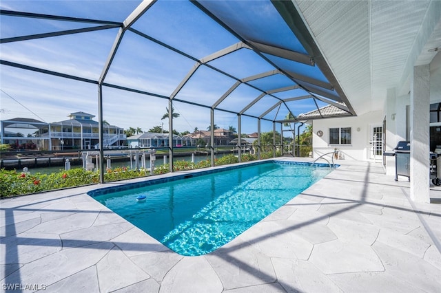 view of swimming pool with a patio area, a grill, and a lanai