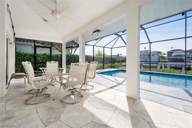 view of swimming pool with a patio, ceiling fan, and glass enclosure