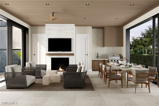 interior space featuring grilling area, an outdoor living space with a fireplace, sink, ceiling fan, and exterior kitchen