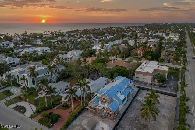 aerial view at dusk featuring a water view