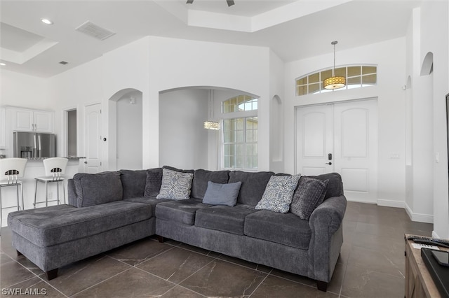 tiled living room featuring a towering ceiling