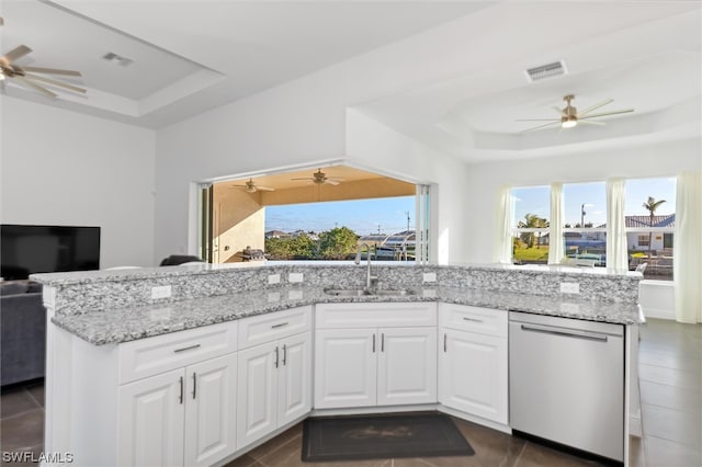 kitchen with dishwasher, a wealth of natural light, white cabinetry, and a tray ceiling