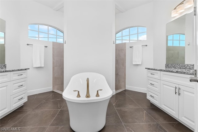 bathroom with a healthy amount of sunlight, tile flooring, and vanity