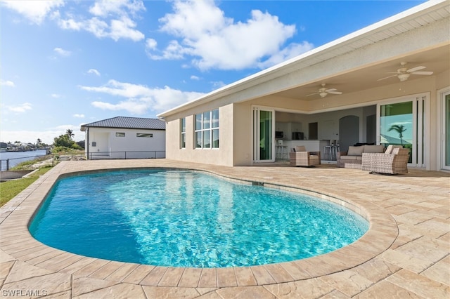 view of pool featuring an outdoor living space, ceiling fan, and a patio