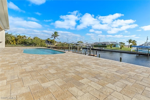 view of swimming pool featuring a water view, a dock, and a patio