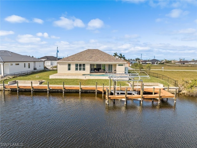 view of dock with a water view and a lawn