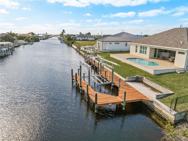 view of dock featuring a patio area, a lawn, and a water view