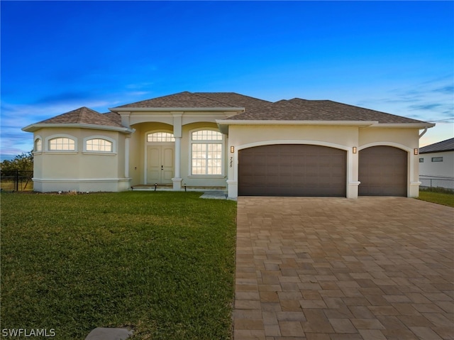 view of front of property with a garage and a front lawn