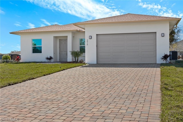 view of front facade with central AC, a garage, and a front lawn