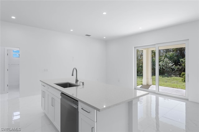 kitchen with stainless steel dishwasher, an island with sink, white cabinetry, light tile patterned floors, and sink