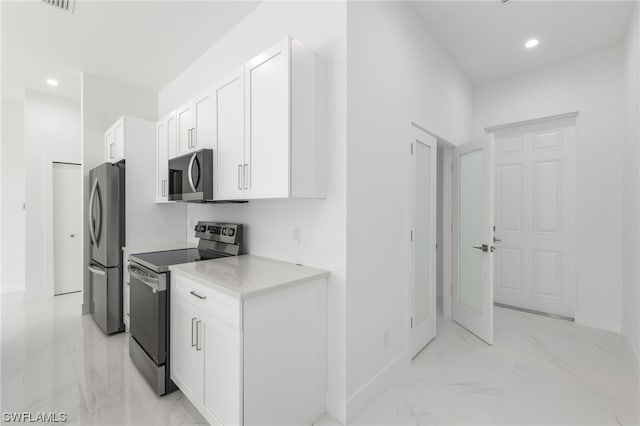 kitchen featuring stainless steel appliances, white cabinets, and light tile patterned floors