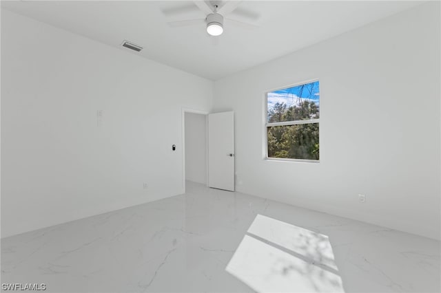 tiled spare room featuring ceiling fan