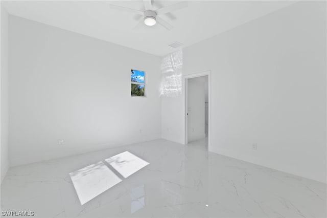 tiled spare room featuring ceiling fan