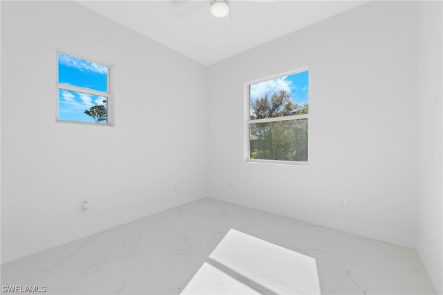 tiled empty room featuring ceiling fan