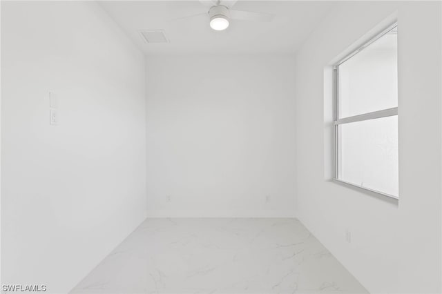 tiled empty room featuring ceiling fan