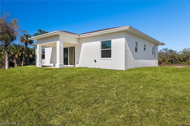 rear view of house featuring a yard