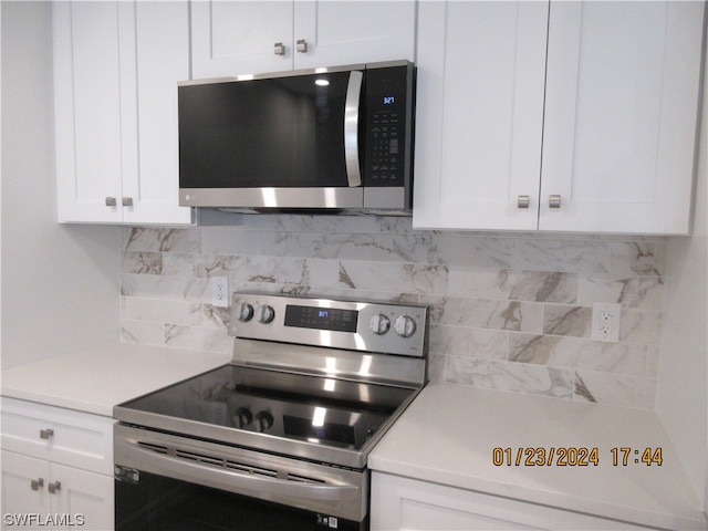 kitchen featuring white cabinets, backsplash, and stainless steel appliances