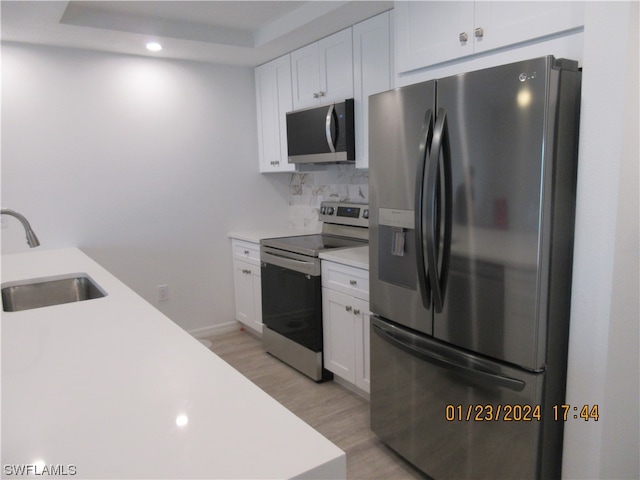 kitchen featuring white cabinets, light hardwood / wood-style flooring, appliances with stainless steel finishes, and sink