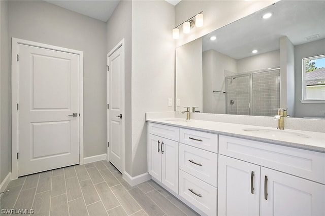 bathroom featuring an enclosed shower, double sink, and oversized vanity