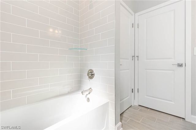 bathroom featuring tiled shower / bath and tile flooring