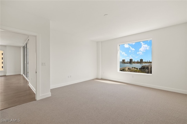 carpeted spare room featuring baseboards