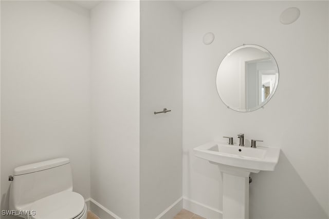 bathroom featuring toilet and baseboards