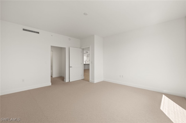 unfurnished bedroom with light carpet, visible vents, and baseboards