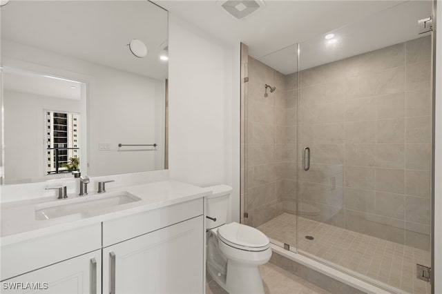 bathroom featuring vanity, a shower stall, toilet, and tile patterned floors