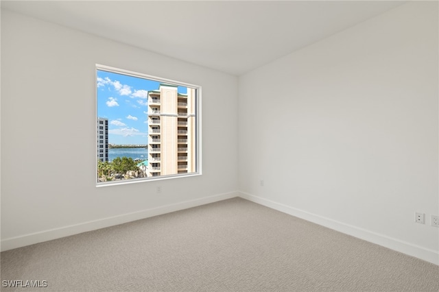 unfurnished room featuring carpet floors and baseboards