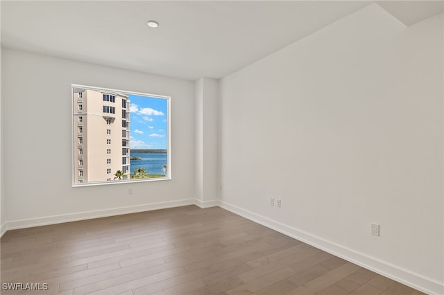 spare room featuring baseboards and wood finished floors