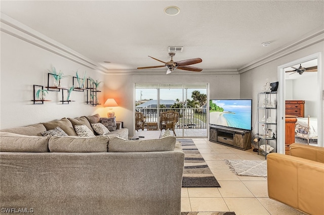 tiled living room with ceiling fan and crown molding