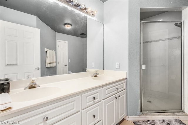 bathroom with a shower with door and dual bowl vanity