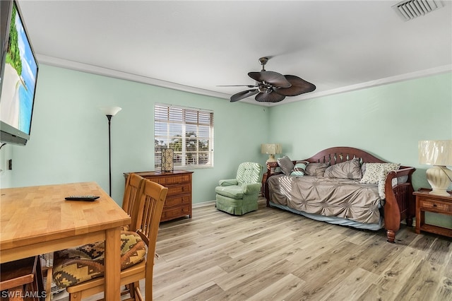 bedroom with light hardwood / wood-style flooring, ceiling fan, and ornamental molding