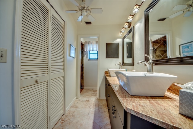 bathroom with double sink vanity, tile floors, and ceiling fan