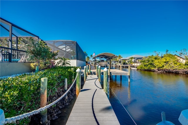 view of dock with glass enclosure and a water view