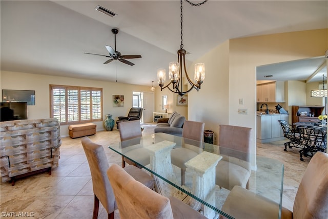 tiled dining room featuring lofted ceiling, sink, and ceiling fan with notable chandelier