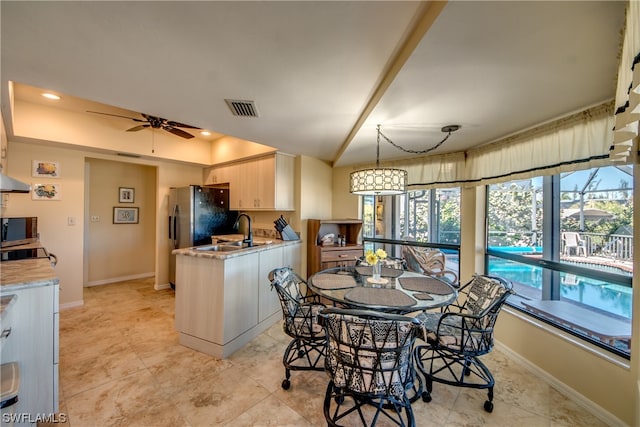 dining space featuring sink, ceiling fan, and light tile flooring