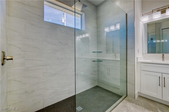 bathroom featuring a tile shower and vanity