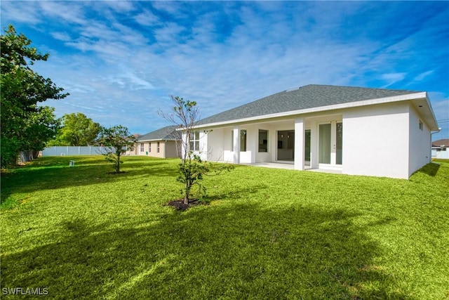 rear view of house with a patio area and a lawn