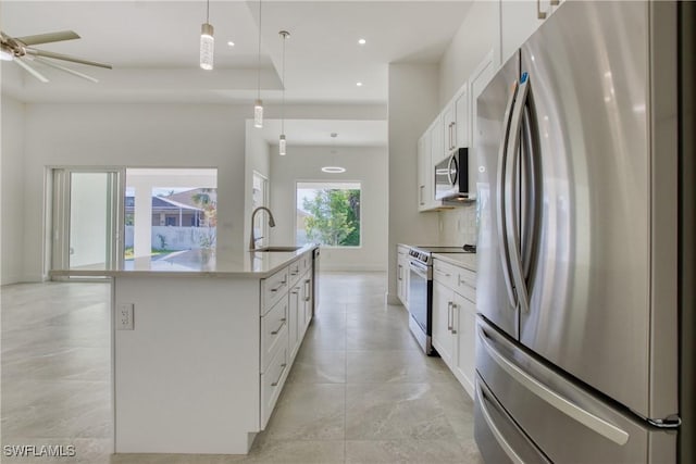 kitchen featuring white cabinetry, sink, decorative light fixtures, a kitchen island with sink, and appliances with stainless steel finishes