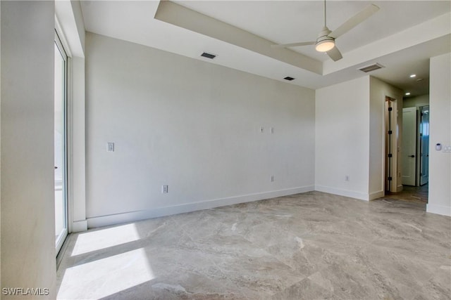 spare room with a raised ceiling and ceiling fan