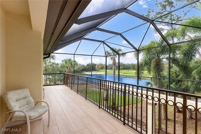 view of patio / terrace featuring a water view and glass enclosure