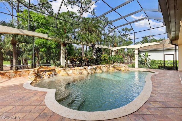 view of pool featuring a lanai, pool water feature, a patio, and a hot tub