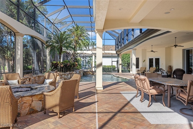 view of patio / terrace featuring glass enclosure, ceiling fan, and french doors