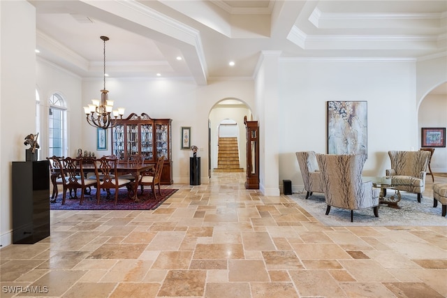 interior space featuring a towering ceiling, crown molding, and an inviting chandelier